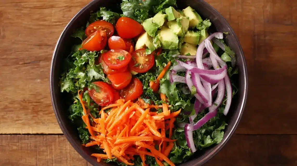 Adding vegetables to salad base Chicken tender salad topped with avocado, tomatoes, and carrots