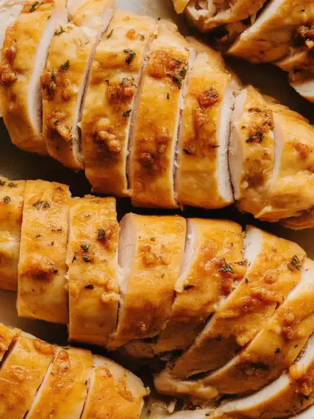 Plated juicy crock pot chicken breast garnished with herbs and spices.