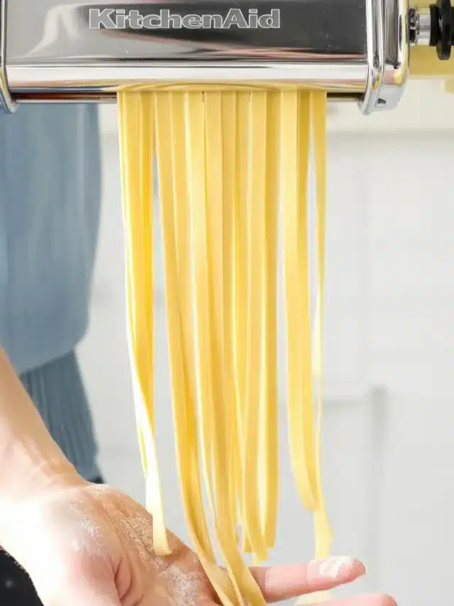 Homemade fresh pasta made with flour, eggs, and olive oil on a wooden surface.