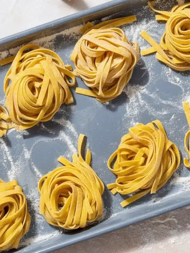 Fresh pasta dough made from flour and eggs on a clean work surface.