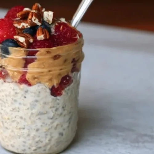 High-protein overnight oats with fruits and nuts in a glass jar