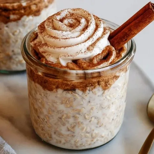 Delicious cinnamon roll overnight oats topped with cinnamon and pecans.