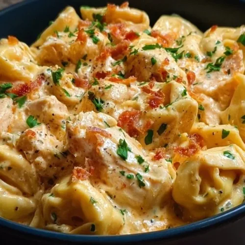 Creamy CrockPot Chicken Tortellini served in a bowl, garnished with parsley.