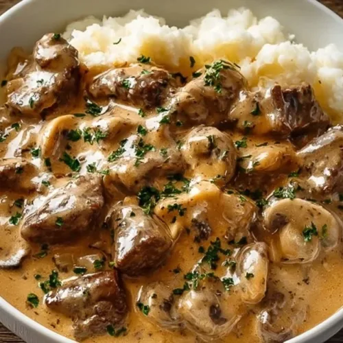 Gordon Ramsay's Beef Stroganoff served in a bowl with garnishes.