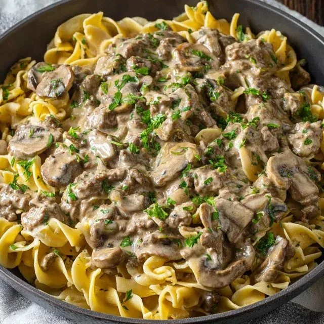 Plate of Ground Beef Stroganoff served with noodles and parsley garnish