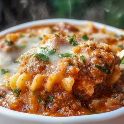 High protein lasagna soup in a bowl with fresh herbs and cheese garnish