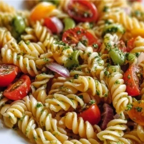 Colorful and fresh pasta salad with vegetables and dressing served in a bowl