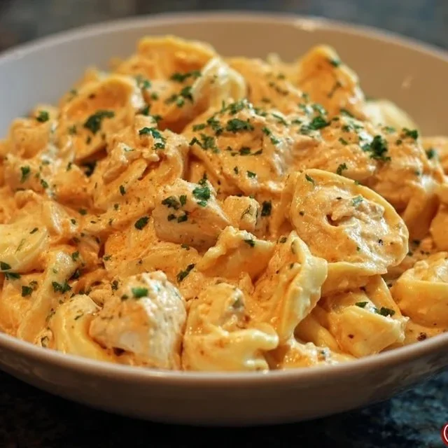 A bowl of easy Crockpot Chicken Tortellini with vegetables and herbs