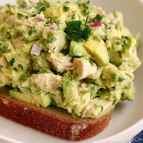 Quick and easy avocado chicken salad topped with fresh ingredients and served in a bowl.