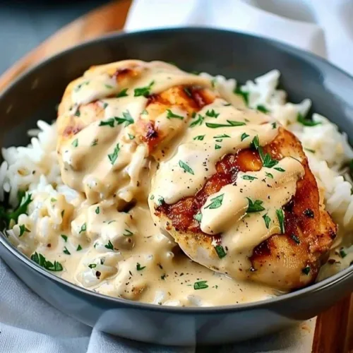 Creamy smothered chicken served with rice in a rich sauce