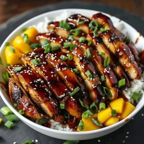 Plate of Asian mango glazed chicken with vibrant colors and garnishes