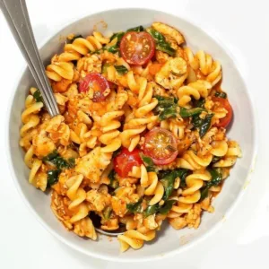 Creamy ground chicken pasta served in a bowl, garnished with herbs.