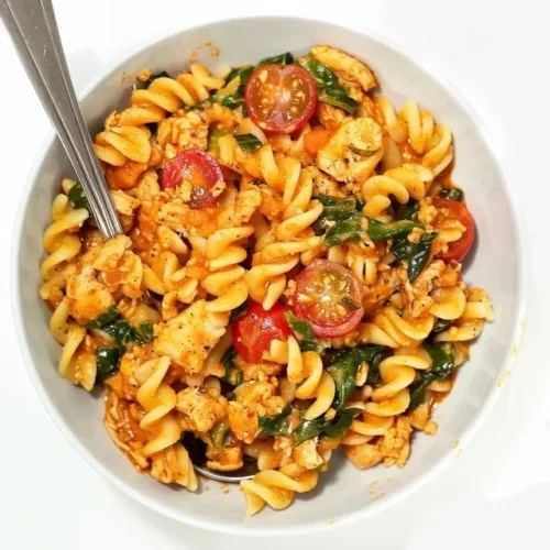 Creamy ground chicken pasta served in a bowl, garnished with herbs.
