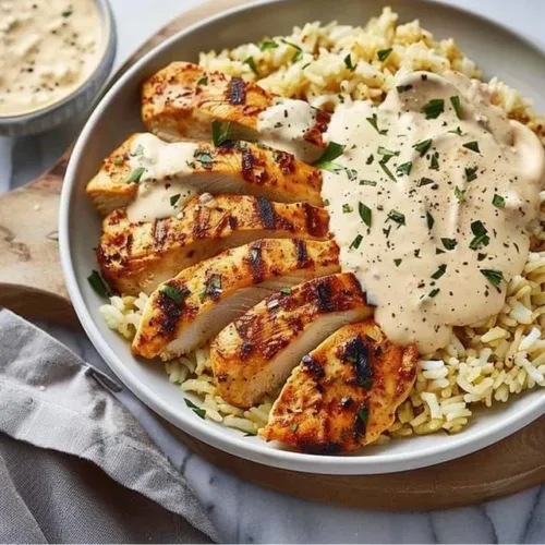 Creamy smothered chicken served over fluffy rice in a comforting dish.