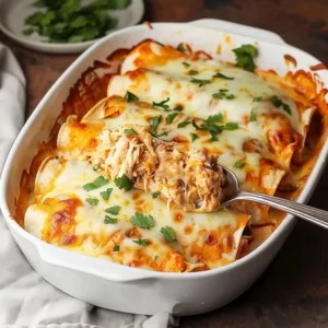 Plate of cheesy shredded chicken enchiladas drizzled with sauce